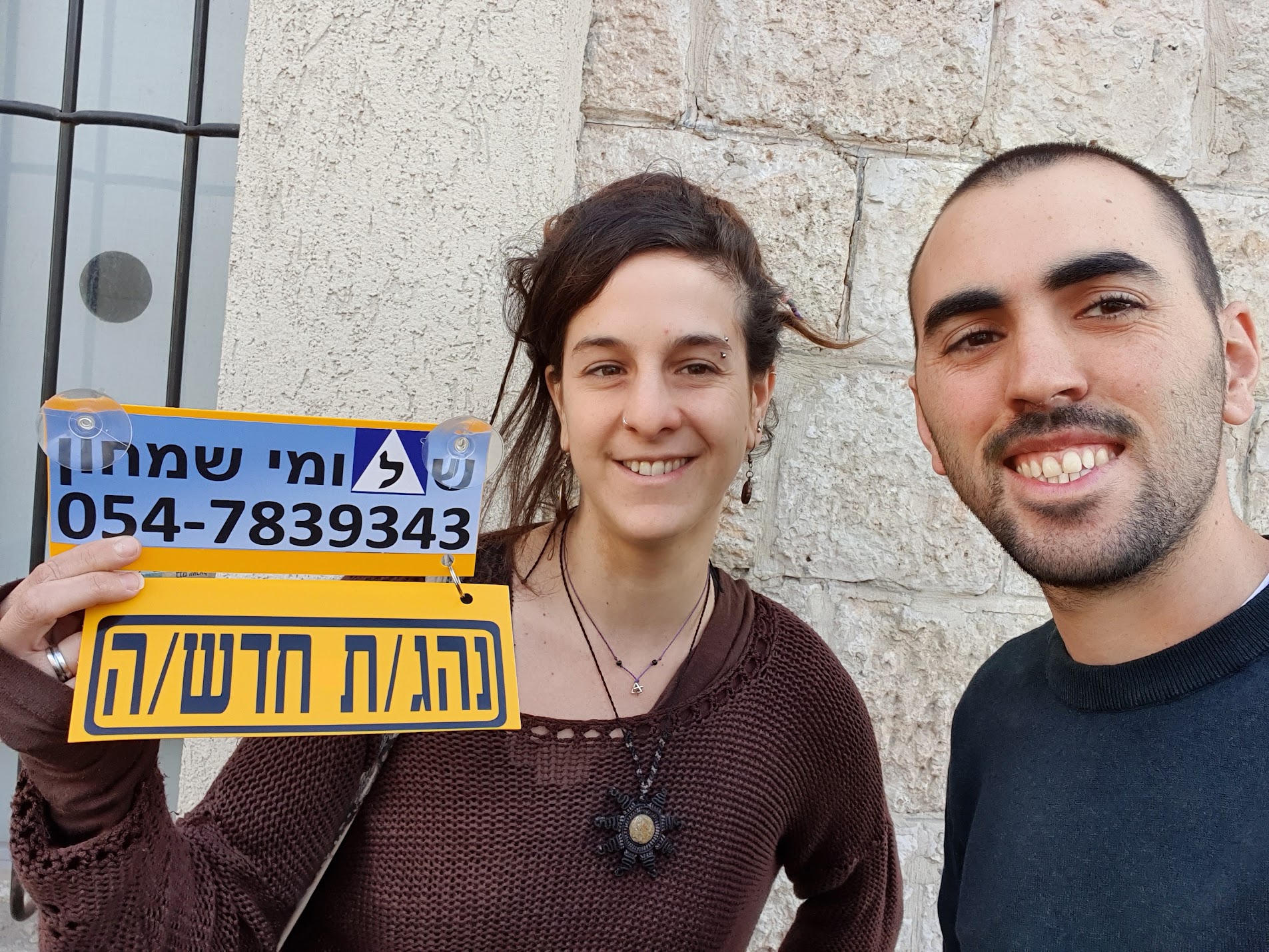 תלמיד עם שלומי שמחון, מורה נהיגה, מחזיק שלט "נהג חדש" לאחר המבחן – תמונה 8