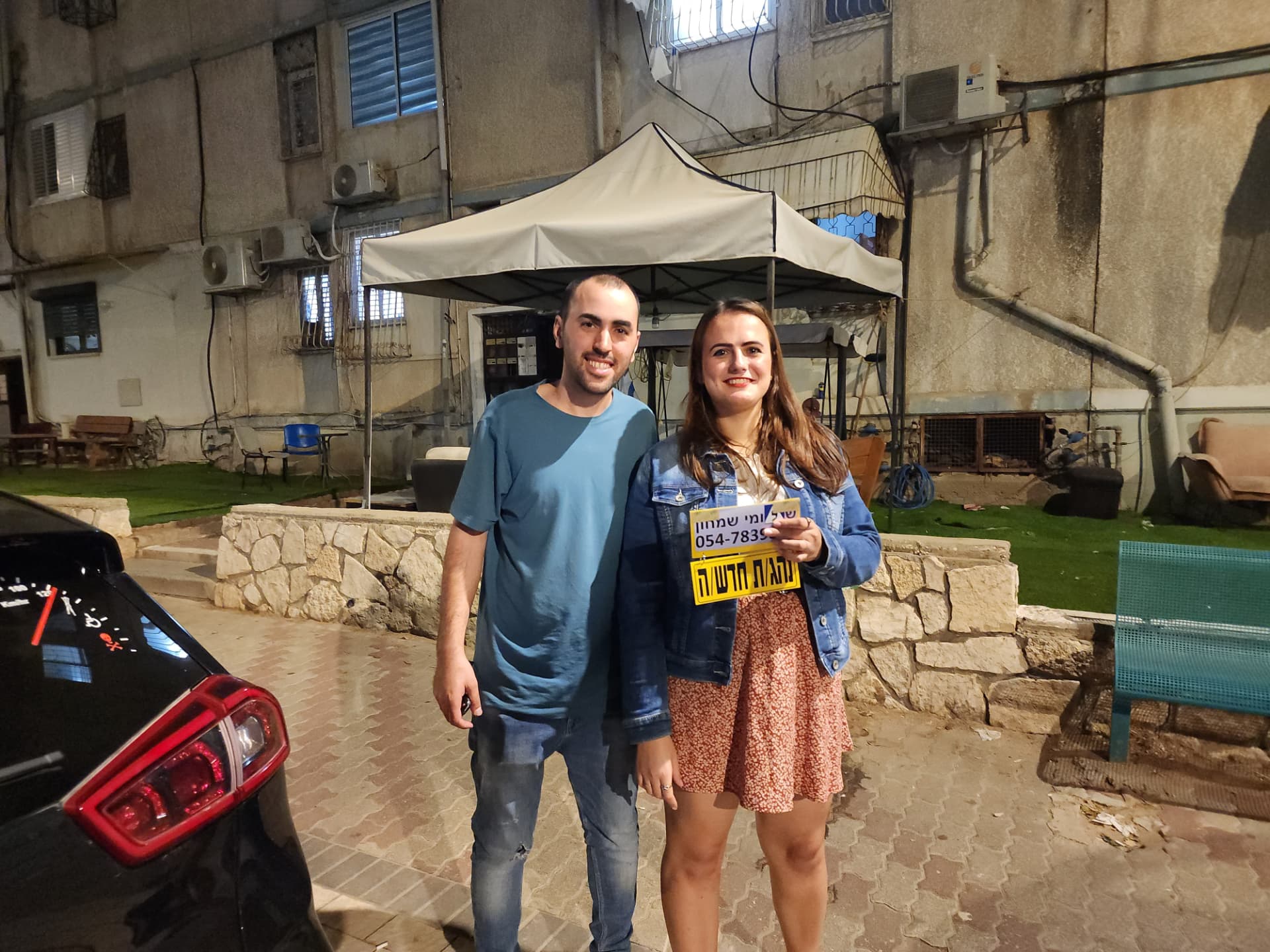 תלמיד עם שלומי שמחון, מורה נהיגה, מחזיק שלט "נהג חדש" לאחר המבחן – תמונה 37