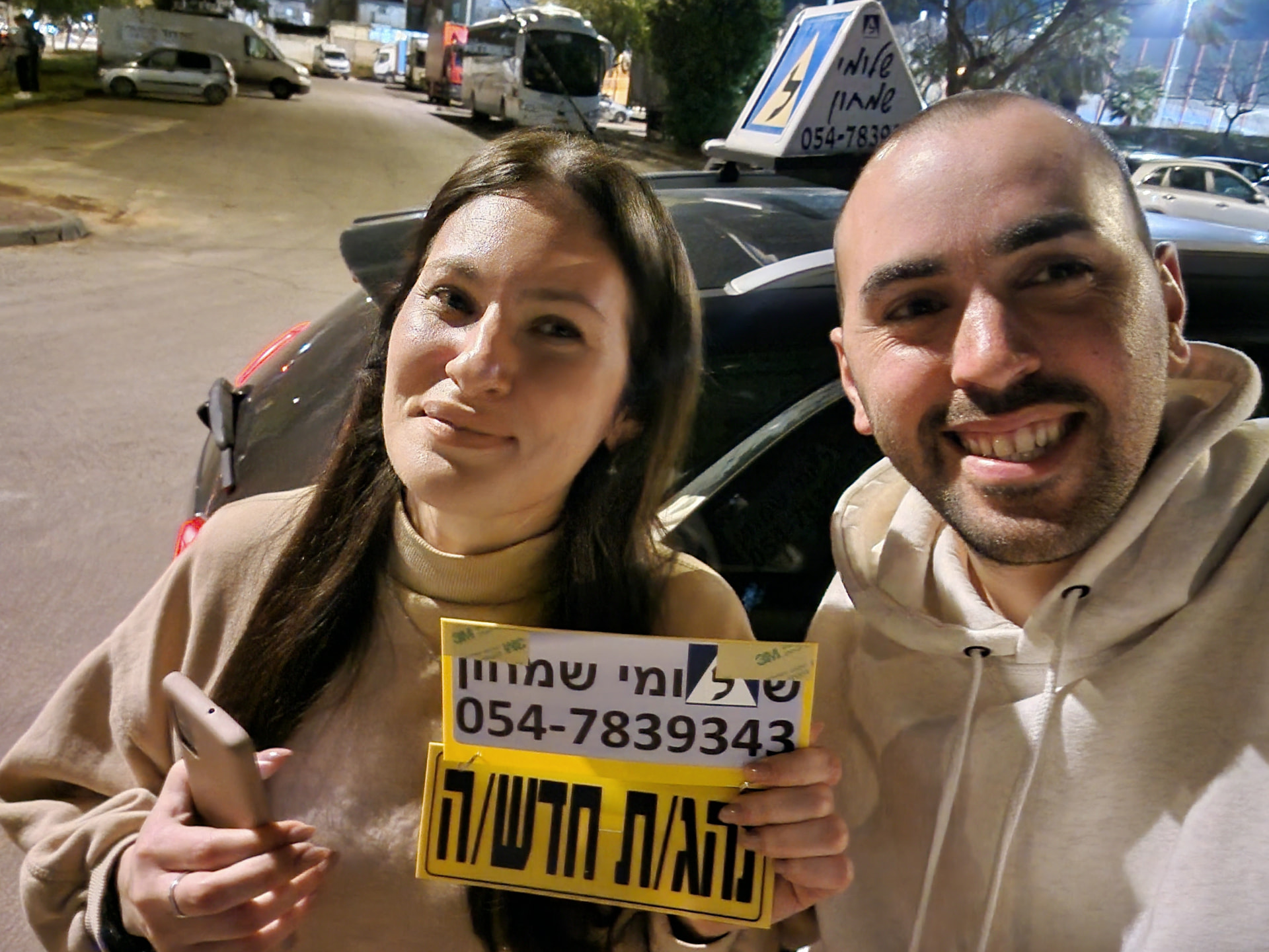 תלמיד עם שלומי שמחון, מורה נהיגה, מחזיק שלט "נהג חדש" לאחר המבחן – תמונה 40