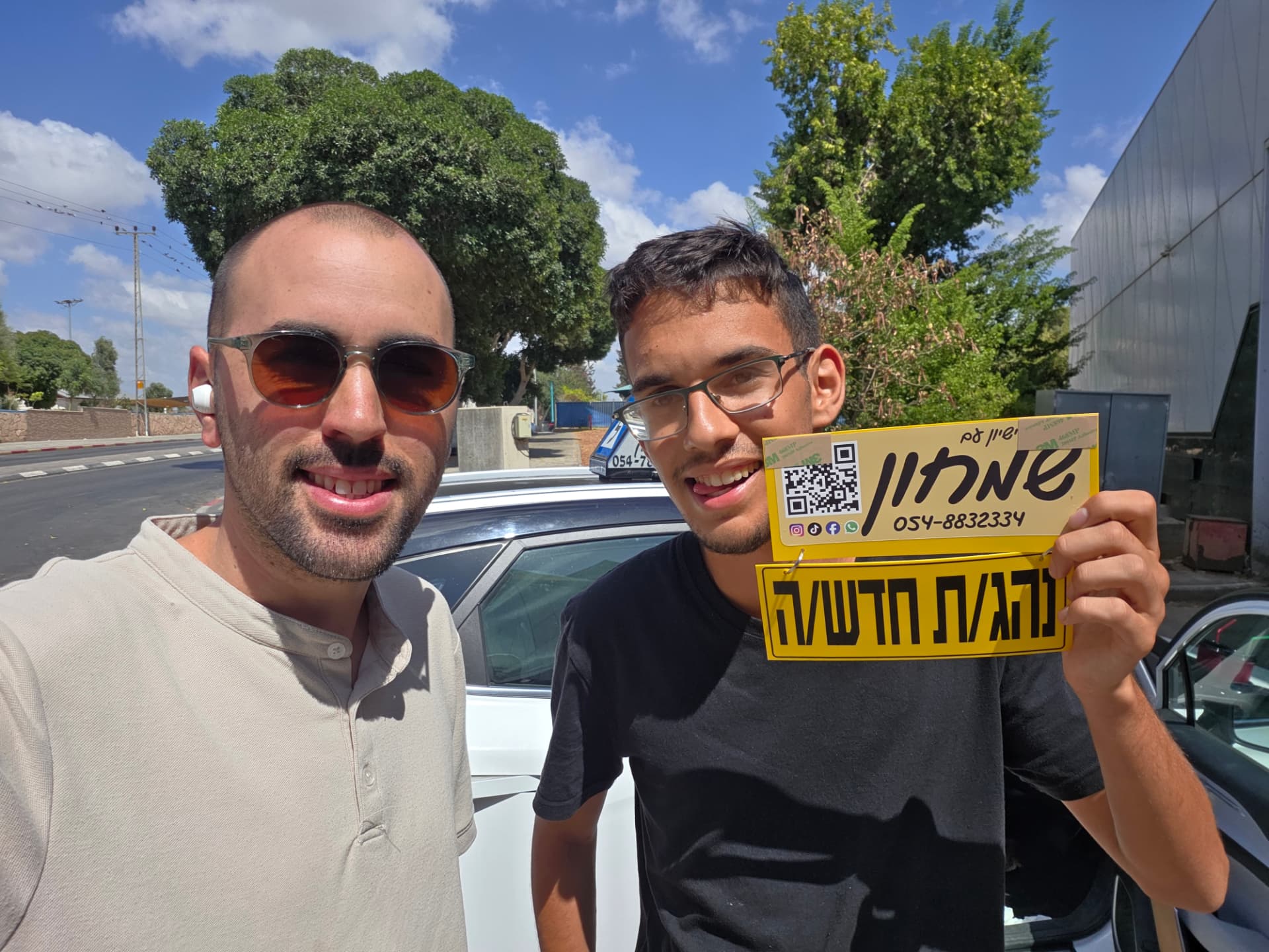תלמיד עם שלומי שמחון, מורה נהיגה, מחזיק שלט "נהג חדש" לאחר המבחן – תמונה 10