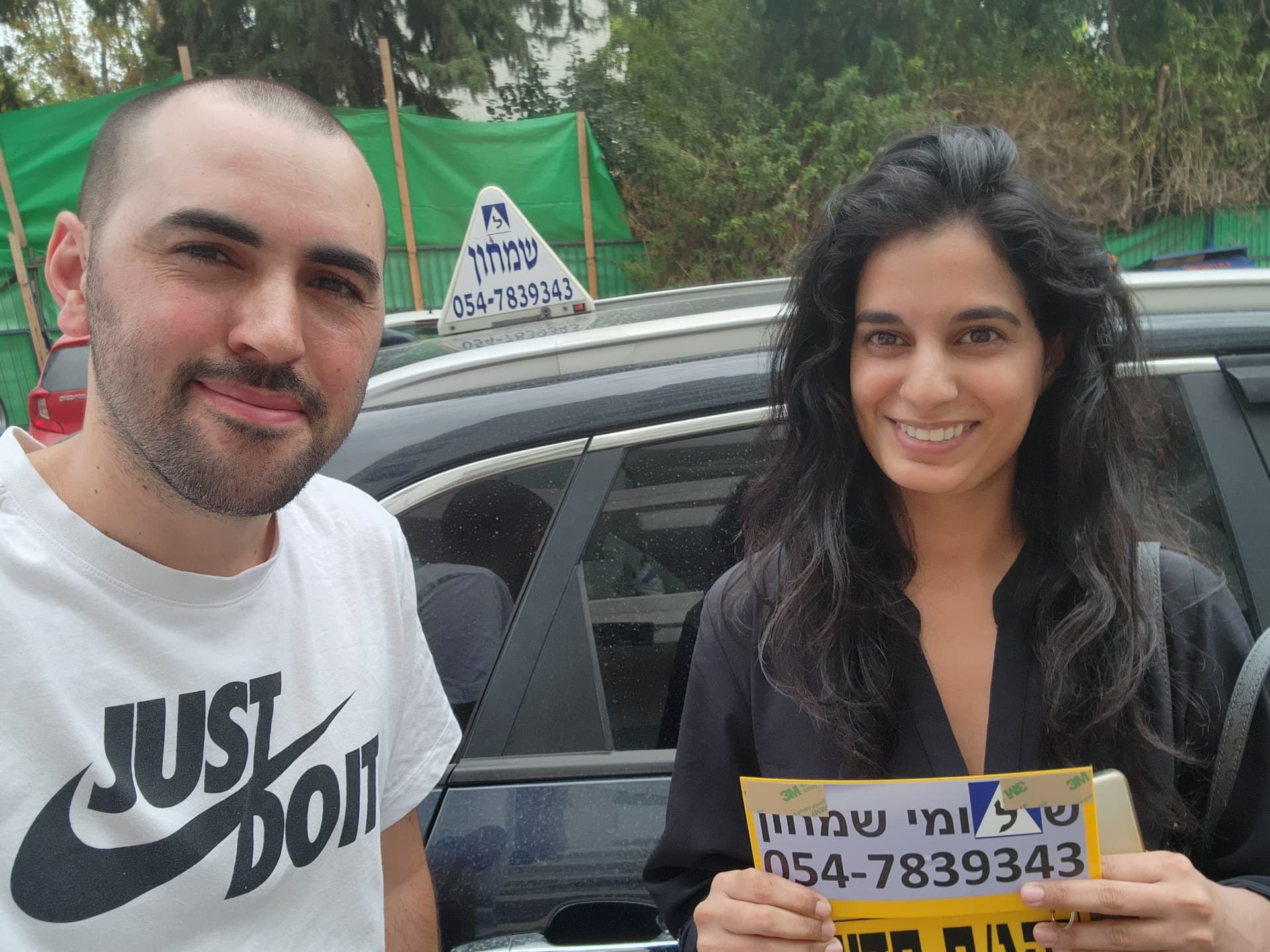 תלמיד עם שלומי שמחון, מורה נהיגה, מחזיק שלט "נהג חדש" לאחר המבחן – תמונה 18
