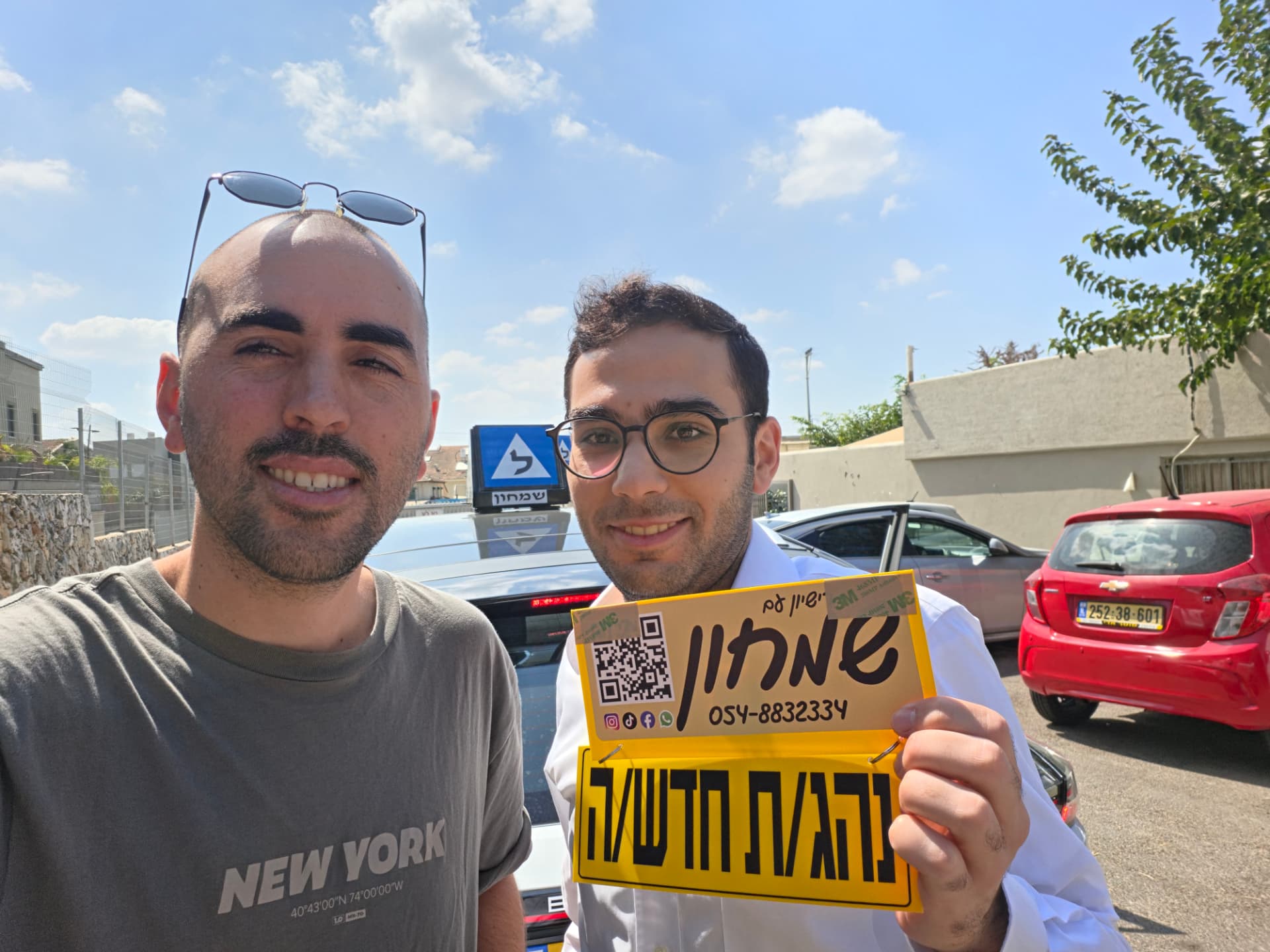 תלמיד עם שלומי שמחון, מורה נהיגה, מחזיק שלט "נהג חדש" לאחר המבחן – תמונה 16