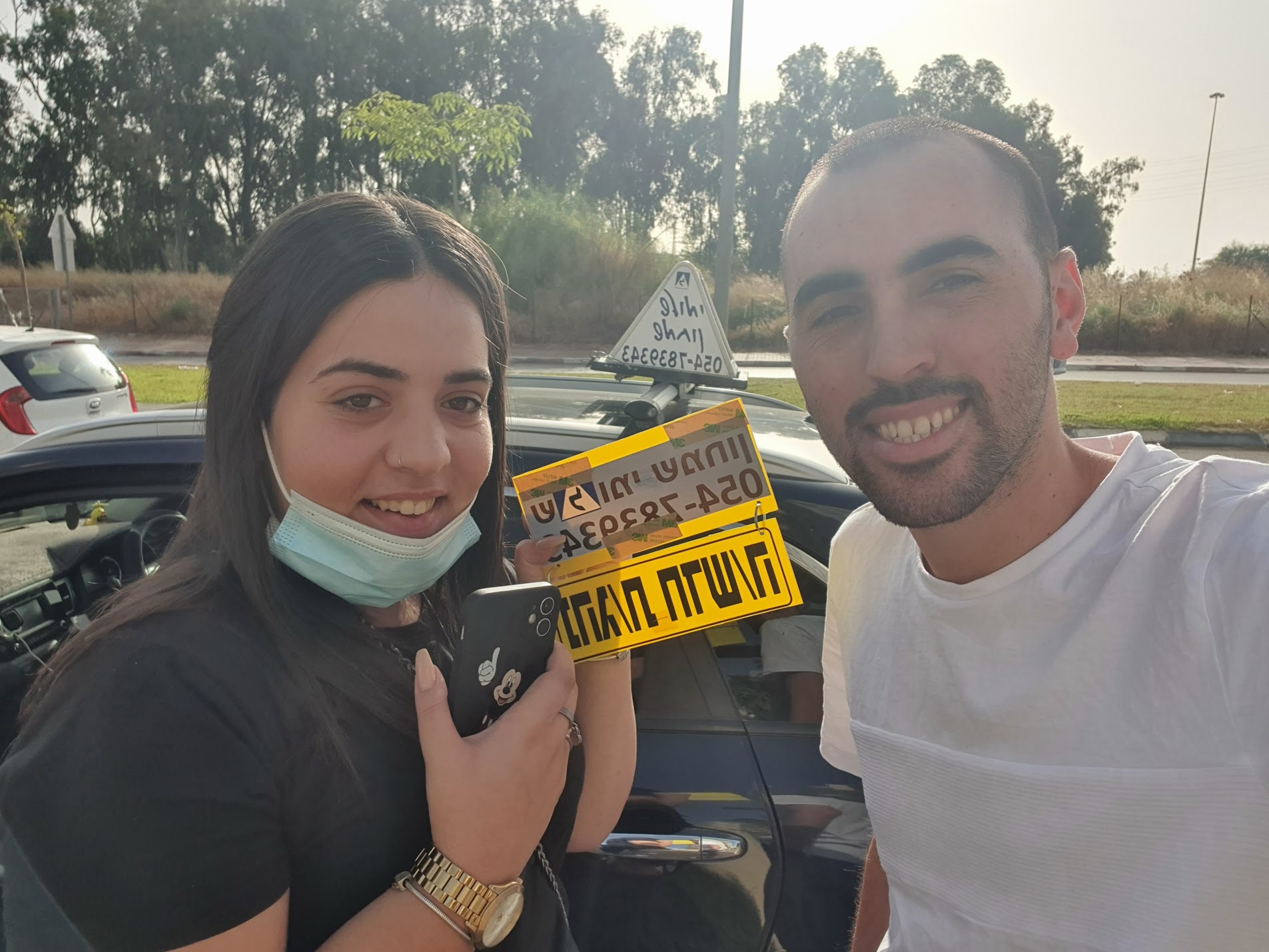 תלמיד עם שלומי שמחון, מורה נהיגה, מחזיק שלט "נהג חדש" לאחר המבחן – תמונה 32