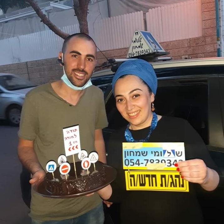תלמיד עם שלומי שמחון, מורה נהיגה, מחזיק שלט "נהג חדש" לאחר המבחן – תמונה 31
