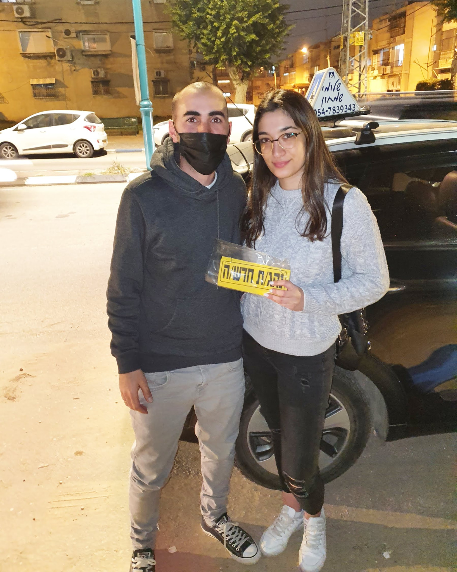 תלמיד עם שלומי שמחון, מורה נהיגה, מחזיק שלט "נהג חדש" לאחר המבחן – תמונה 65