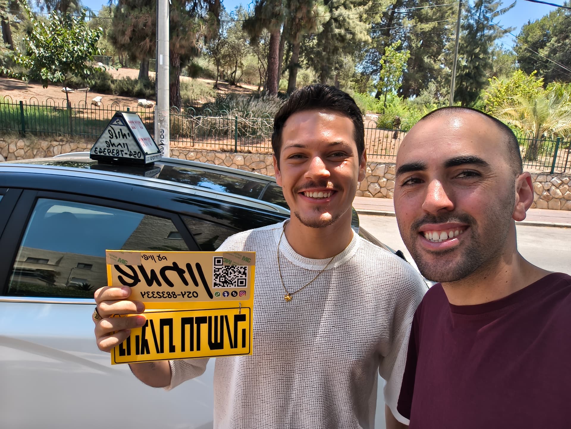 תלמיד עם שלומי שמחון, מורה נהיגה, מחזיק שלט "נהג חדש" לאחר המבחן – תמונה 57