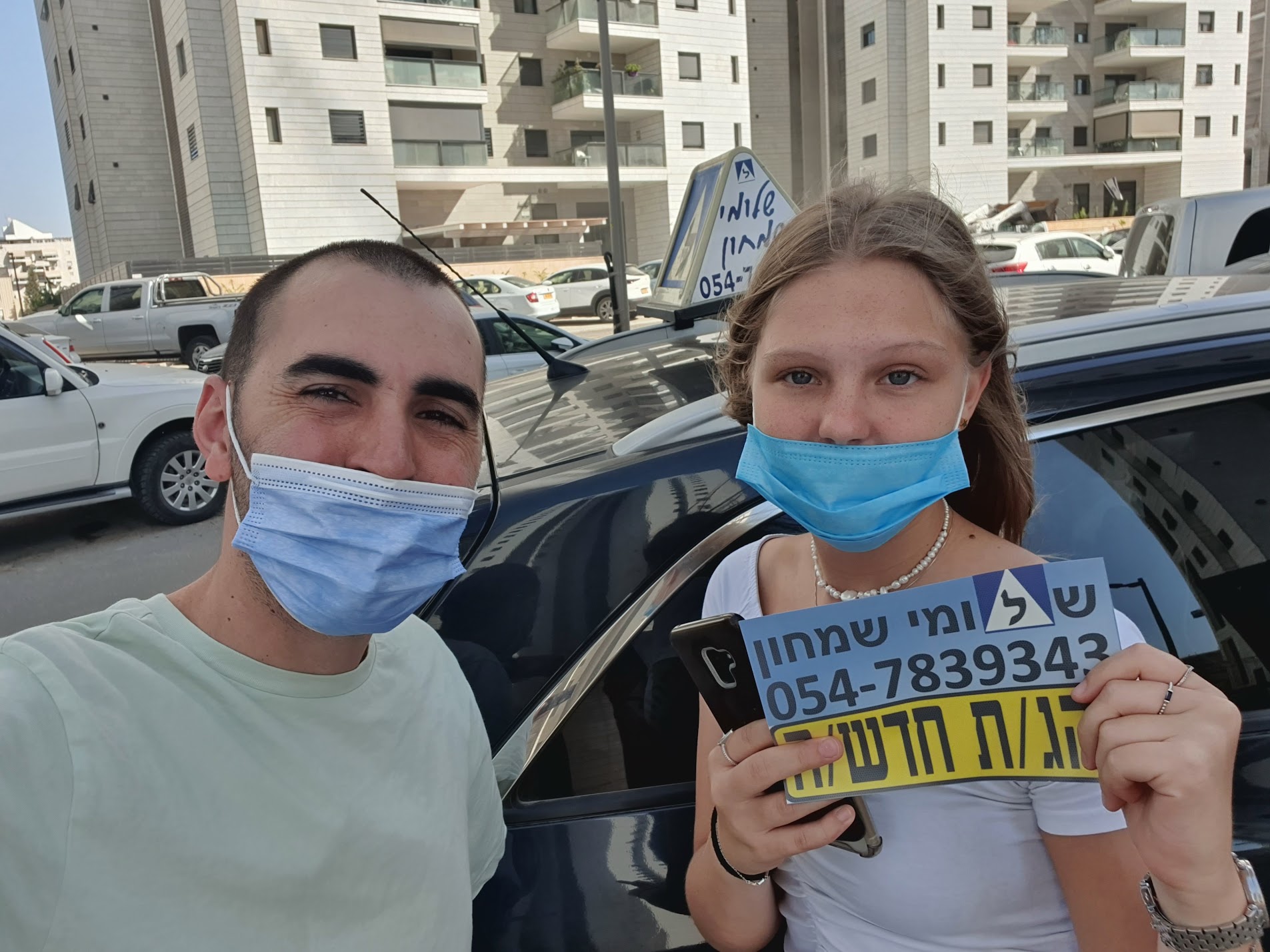 תלמיד עם שלומי שמחון, מורה נהיגה, מחזיק שלט "נהג חדש" לאחר המבחן – תמונה 67