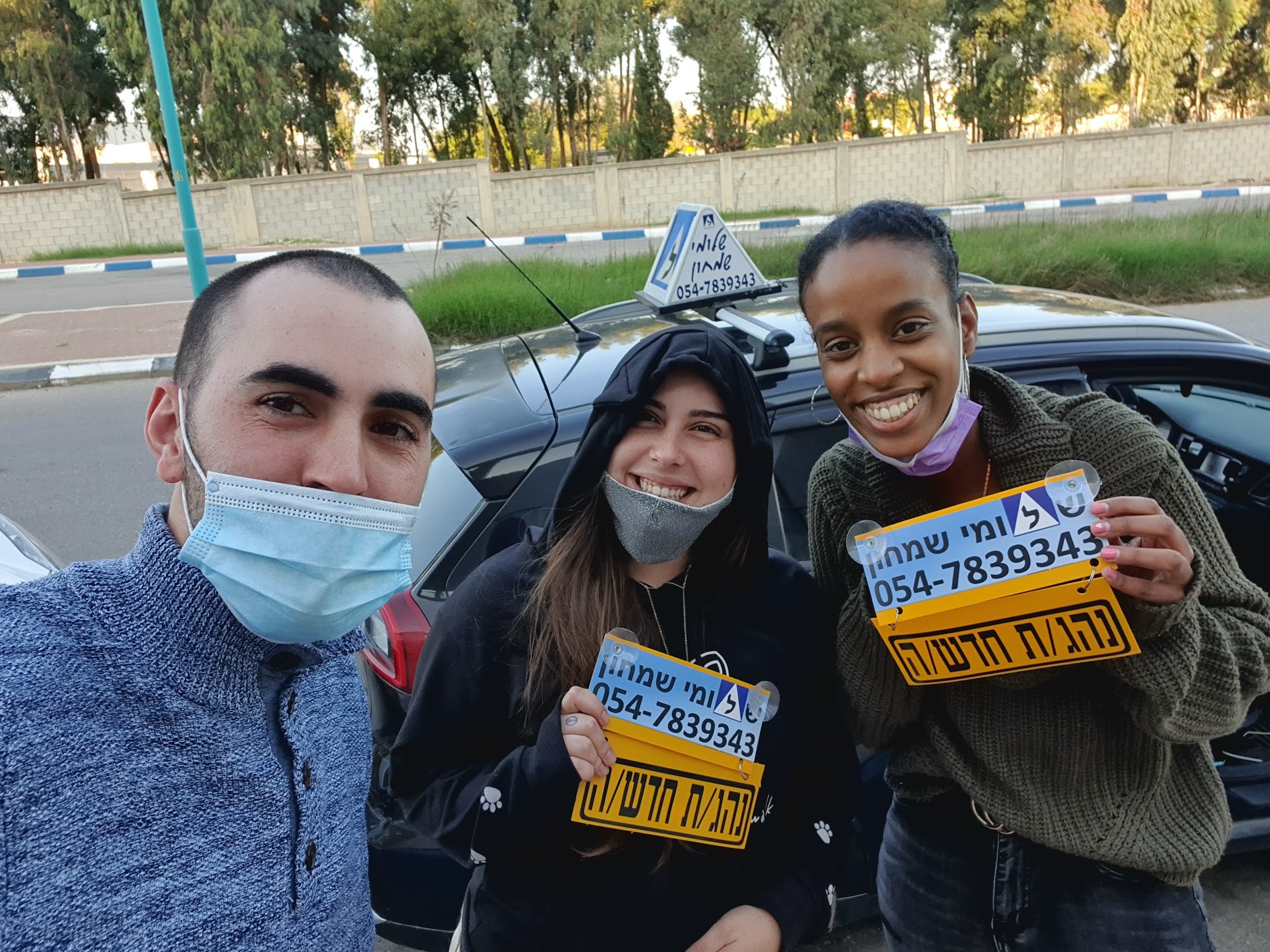 תלמיד עם שלומי שמחון, מורה נהיגה, מחזיק שלט "נהג חדש" לאחר המבחן – תמונה 66