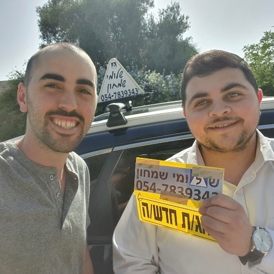 תלמיד עם שלומי שמחון, מורה נהיגה, מחזיק שלט "נהג חדש" לאחר המבחן – תמונה 61